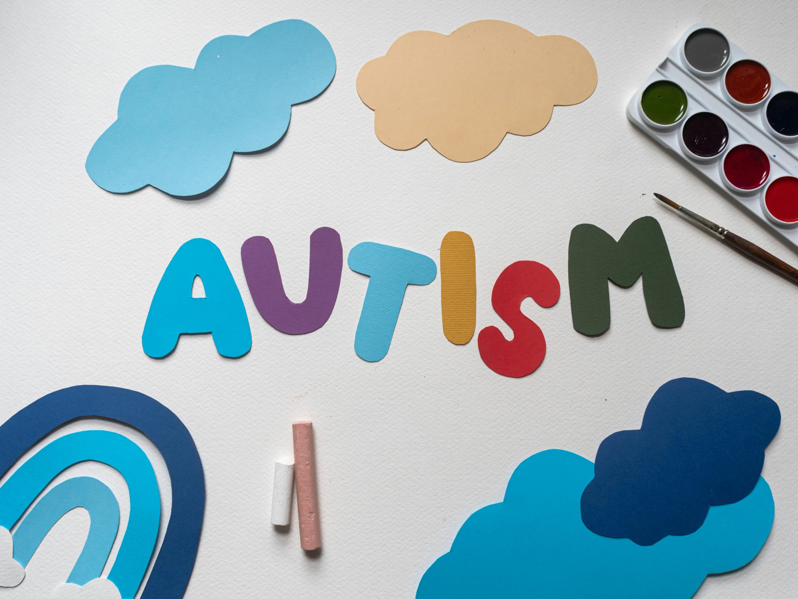 Creative representation of autism awareness with colorful paper cutouts and art materials.